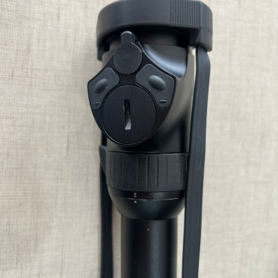 Parte de tripé preto em material metálico e plástico com alavanca e parafuso de aperto