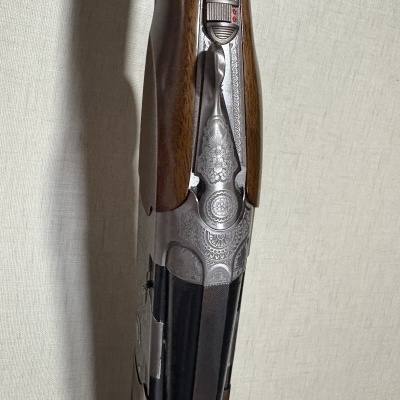 Espingarda com coronha de madeira castanha e gravuras metálicas detalhadas
