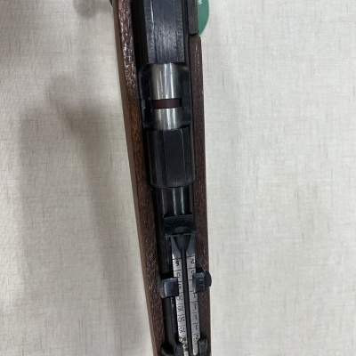 Rifle com coronha em madeira e partes metálicas pretas com visor ajustável