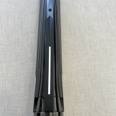 Espingarda preta com acabamento brilhante e detalhes texturizados