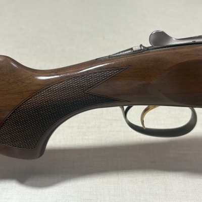 Espingarda com coronha de madeira castanha e guarda-mão metálico