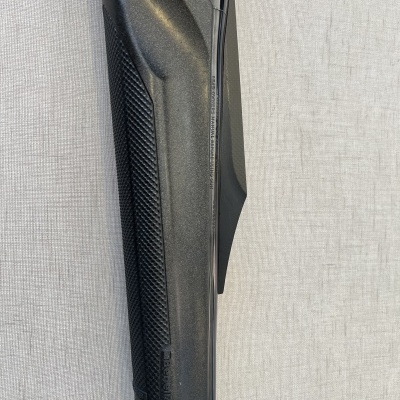 Punho preto de arma de fogo com textura antiderrapante sobre fundo cinza claro