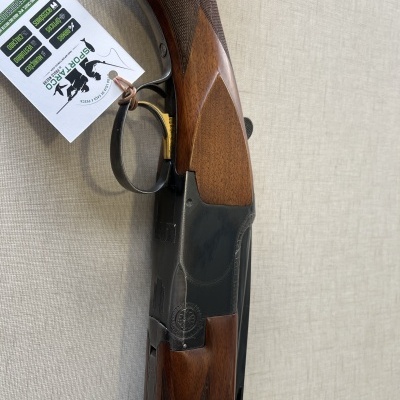 Espingarda com caixa preta e empunhadura de madeira castanha com etiqueta pendurada