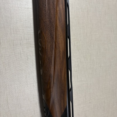 Parte de espingarda com madeira castanha e parte metálica preta