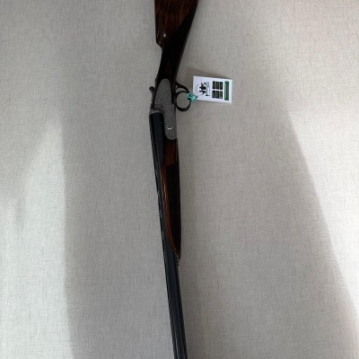 Espingarda de cano duplo com coronha em madeira e metal sobre fundo cinza