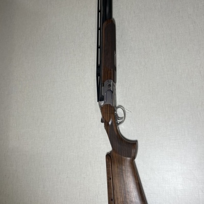 Espingarda de cano duplo com madeira castanha e detalhes metálicos
