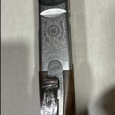 Espingarda com cabo de madeira escura e armação metálica gravada