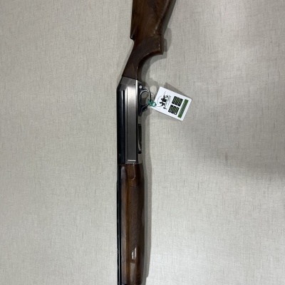 Espingarda de cano duplo com cabo de madeira contra parede clara