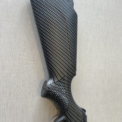 Caneleira preta e cinza com textura tipo fibra de carbono sobre superfície bege claro