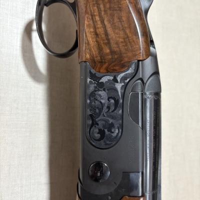 Parte de espingarda com madeira castanha e metal preto gravado