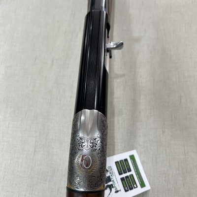 Espingarda com gravuras e número 50 na parte metálica prateada