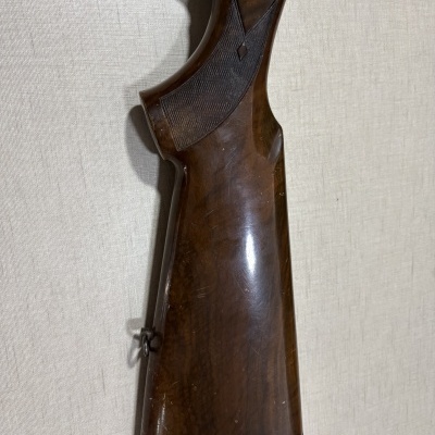 Espingarda de madeira castanha contra fundo claro