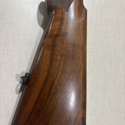 Coronha de madeira castanha com detalhe texturizado e suporte metálico preto