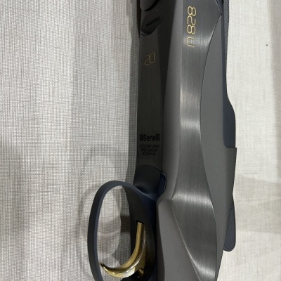 Parte de uma espingarda Benelli 828 U com punho em madeira e detalhes metálicos