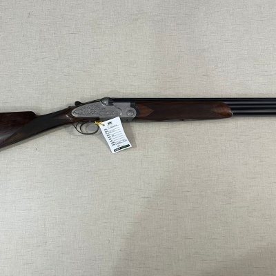 Espingarda de canos duplos e coronha em madeira escura sobre fundo bege