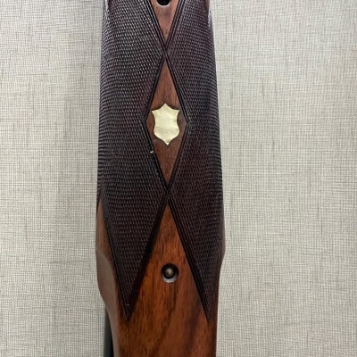 Coronha de madeira com textura quadriculada e ornamento metálico