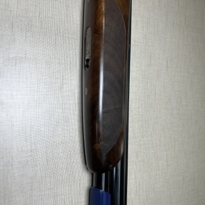 Espingarda Beretta com coronha de madeira castanha e proteção azul