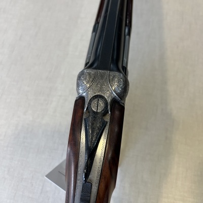 Espingarda de canos duplos com acabamento em madeira e metal gravado