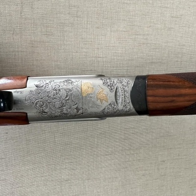 Espingarda com madeira castanha e detalhes metálicos gravados