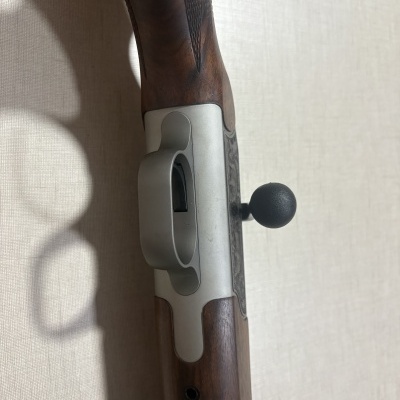 Rifle com madeira castanha e armação metálica prateada