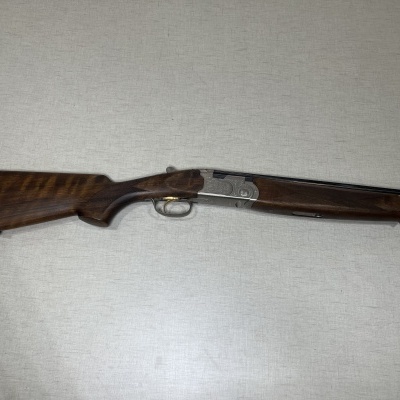 Espingarda de canos duplos com coronha em madeira escura
