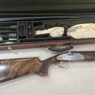 Espingarda de caça com caixa de transporte marrom e acessórios dentro