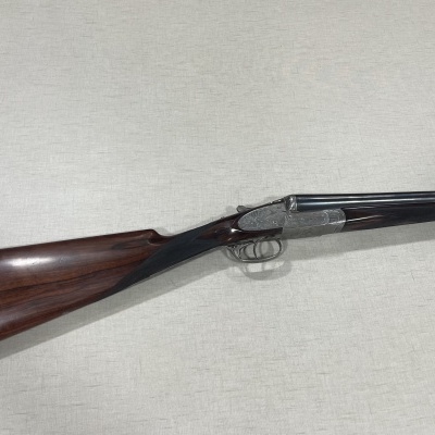 Espingarda de canos duplos com coronha em madeira castanha polida