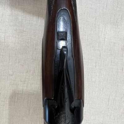 Espingarda de cano duplo com coronha em madeira e detalhes em metal gravado