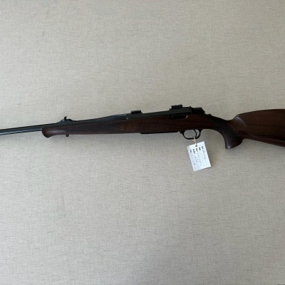 Espingarda com coronha em madeira escura e cano longo em metal preto