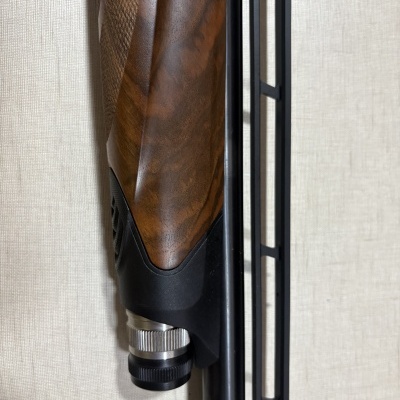 Espingarda com cabo em madeira castanha e parte metálica com anel prateado