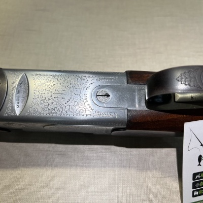 Espingarda de cano duplo com gravações na parte metálica e madeira castanha