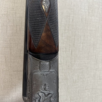 Esteira de espingarda em madeira e metal com gravação detalhada de águia.