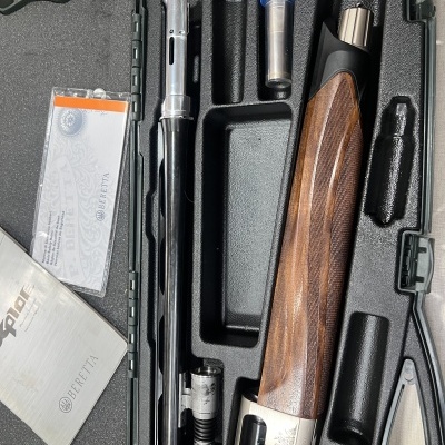 Estojo preto com arma de caça Beretta desmontada e documentos