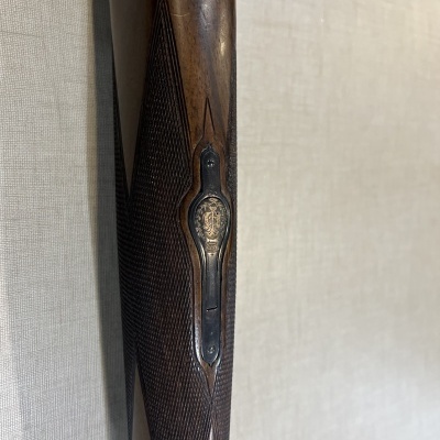 Espingarda com cabo em madeira castanha e detalhes metálicos