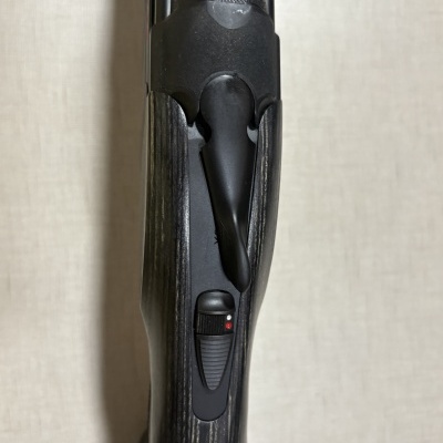 Arma de cano duplo com coronha em madeira e metal preto com interruptor de segurança