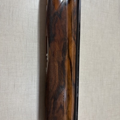 Punho de arma em madeira trabalhada com textura xadrezada