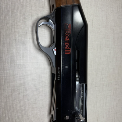 Espingarda Benelli com coronha de madeira e corpo metálico preto