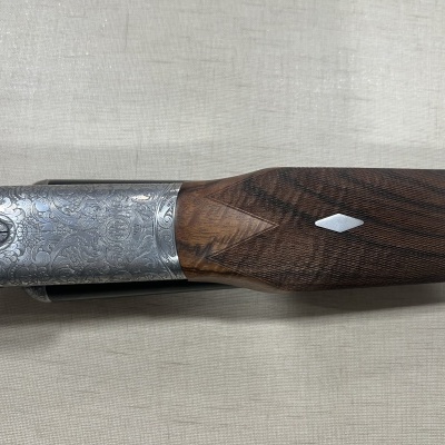 Espingarda com empunhadura de madeira e acabamento em metal gravado