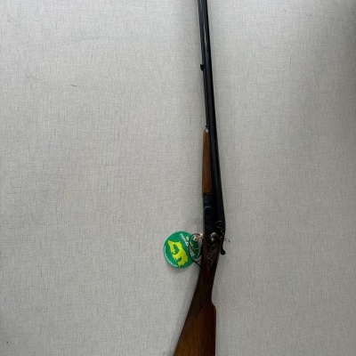 espingarda de canos duplos com acabamento em madeira e metal e etiqueta verde