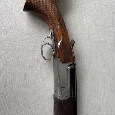 Rifle de caça com coronha em madeira castanha e armação metálica prateada