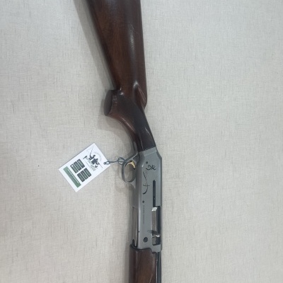 Espingarda de madeira e metal com etiqueta pendurada sobre fundo claro