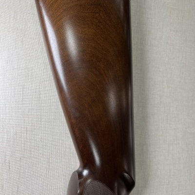 Coronha de arma de fogo em madeira castanha polida com acabamento preto acolchoado