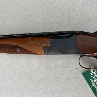 Espingarda de canos sobrepostos com madeira e metal, etiqueta verde pendurada