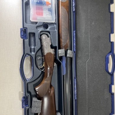 Espingarda de dois canos desmontada num estojo rígido azul escuro