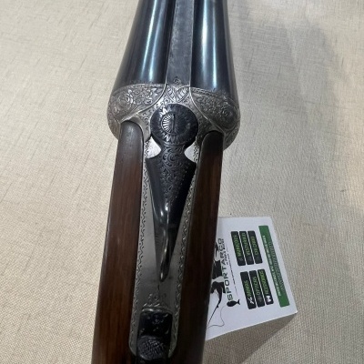 Espingarda de canos duplos com detalhes gravados e coronha de madeira