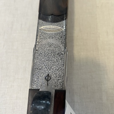 Espingarda com detalhes gravados em metal e madeira escura