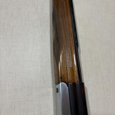 Espingarda com madeira polida e metal preto e prateado