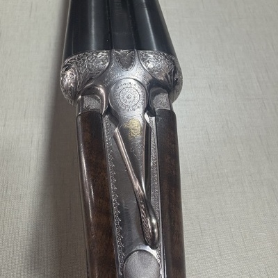 Espingarda de canos duplos com detalles metálicos gravados e coronha em madeira castanha