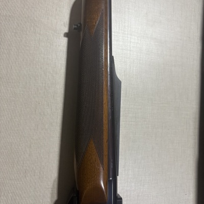 Espingarda com cabo de madeira castanha e partes metálicas pretas