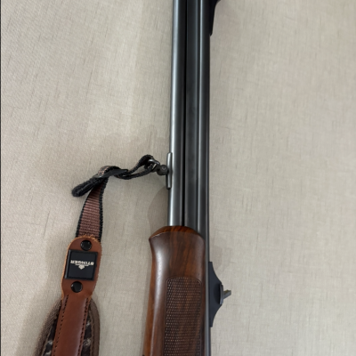 Espingarda de cano duplo com correia castanha e detalhes em madeira
